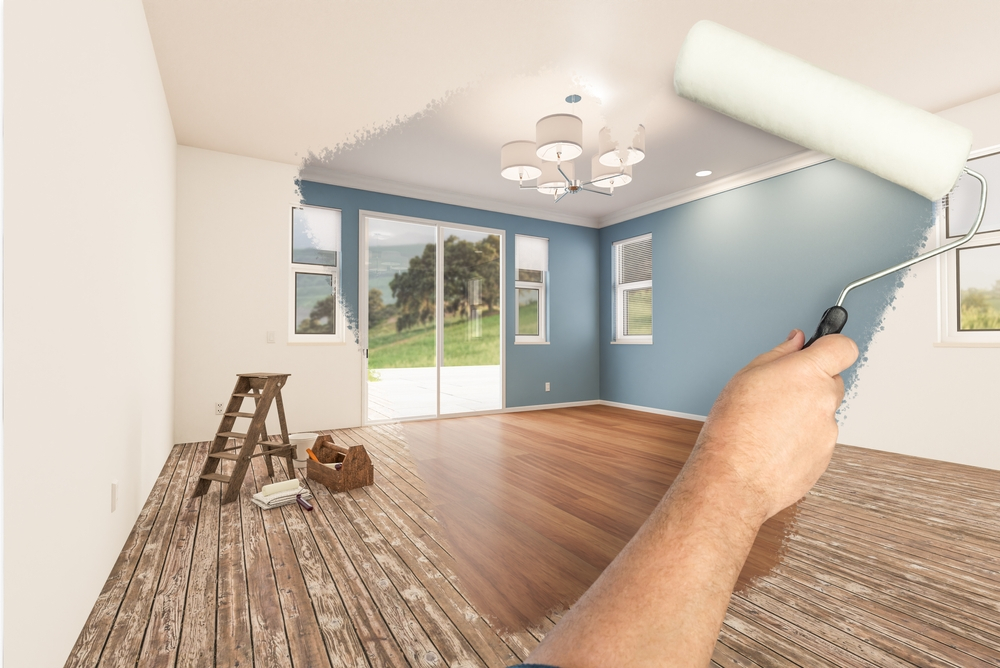 Before and After Man Painted Roller to Reveal Newly Remodeled Bedroom with Fresh Blue Paint and New Floors