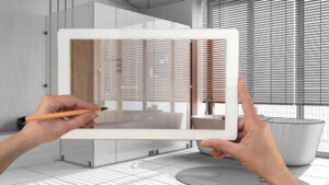 A hand holding a tablet with an AR application used to simulate furniture products in a custom architecture, bathroom remodeling