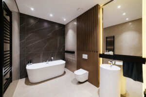 New spacious bathroom featuring white beauty mirror and lighting, a result of quality bathroom remodeling services.